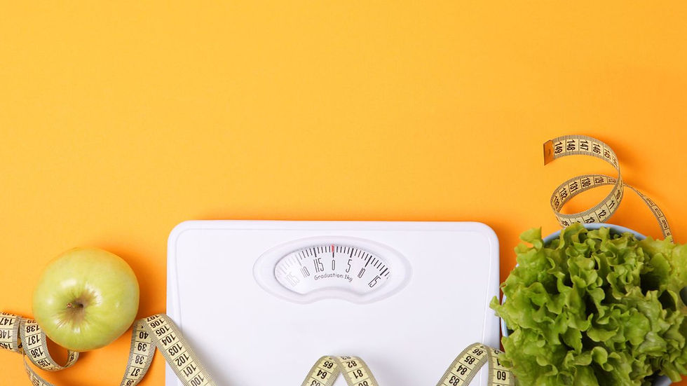 White scale, green apple, lettuce, and measuring tape on orange background, conveying a theme of health and fitness.