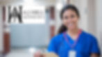 A healthcare worker in blue scrubs and a stethoscope smiles while holding a clipboard in a hospital corridor. A logo for AJ Hill Aesthetics is visible in the top left corner.
