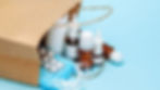 Items spill from a brown paper bag: medicine bottles, blister packs, and blue masks on a light blue background.