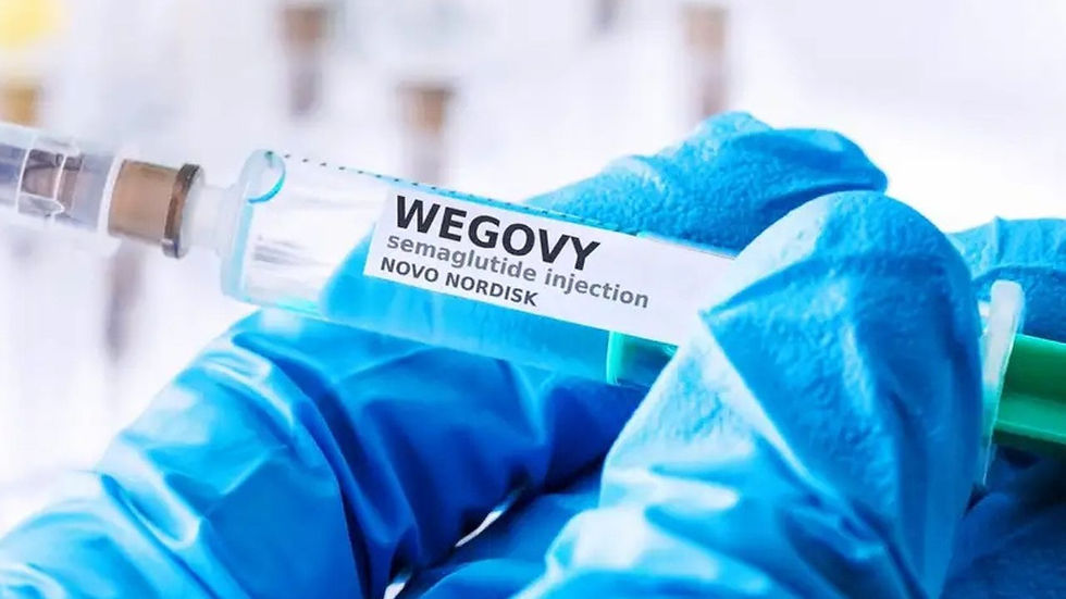 Gloved hand holds a syringe labeled "Wegovy semaglutide injection Novo Nordisk" in a bright, clinical setting. Focus on the label.