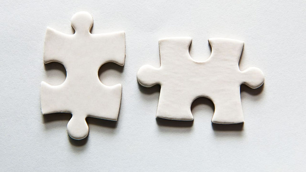 Two white puzzle pieces on a pale background, placed side by side but not connected. Minimalist and simple design.