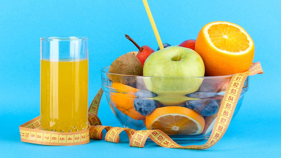 Glass of orange juice and bowl of assorted fruits with a measuring tape on a blue background, conveying a healthy lifestyle theme.