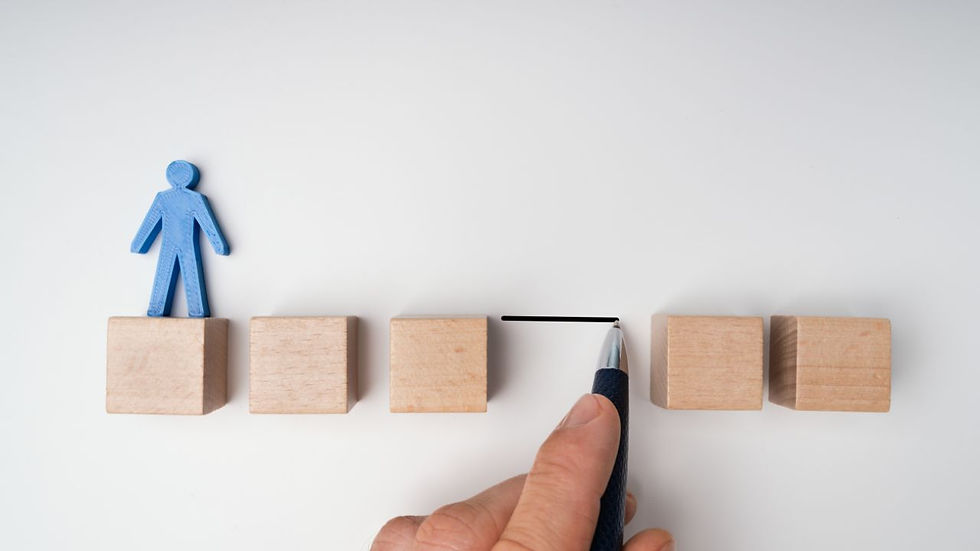 Blue figure on wood block, hand draws a line between blocks with pen on white background. Symbolizes progress or connection.