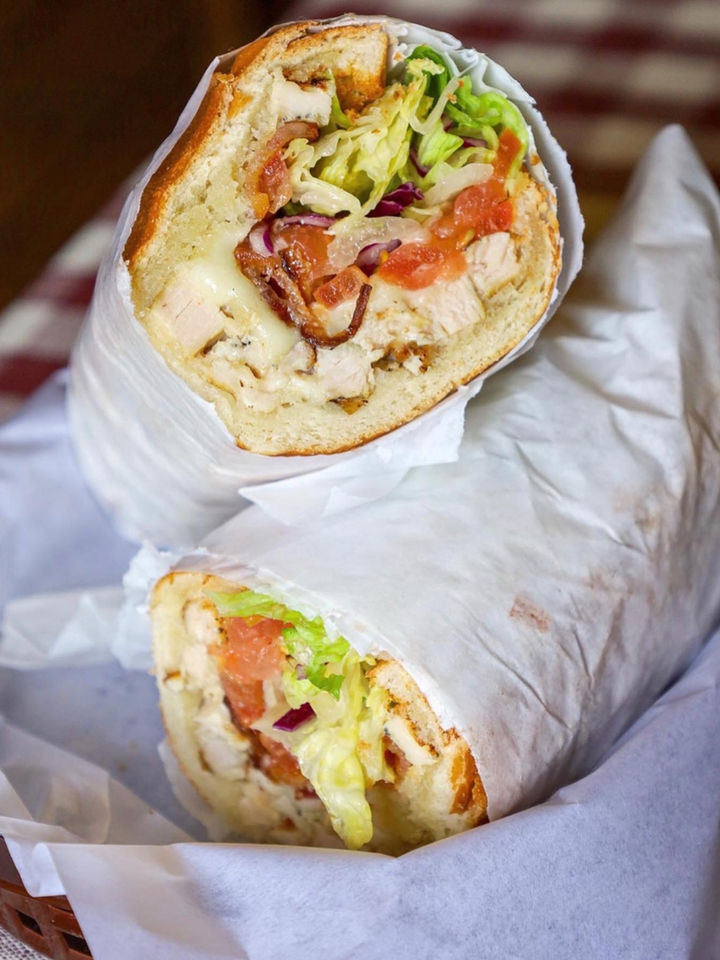Chicken sub sandwich with lettuce, tomato, and onion