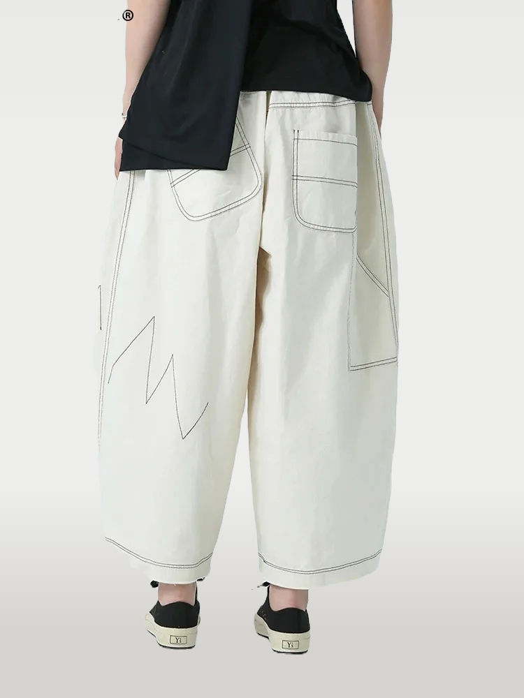Beige wide-leg pants with a high waist, cutout details, and pockets. Made from a cotton blend with slight stretch for comfort