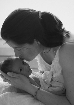 láska v šestinedělí k miminku, matka pusinkuje novorozeně, fotka vyjadřuje nejhlubší lásku.