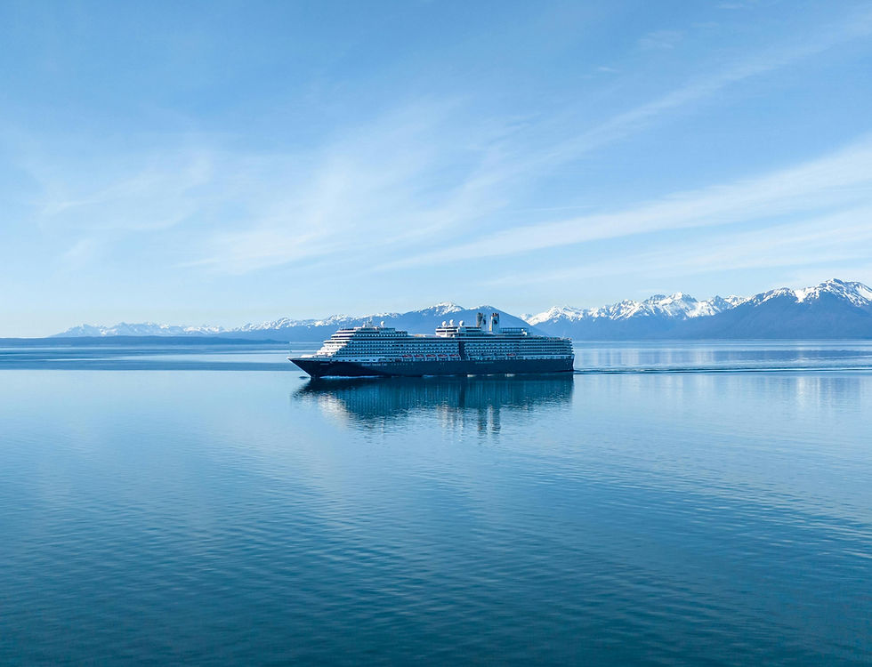 Cruise ship gliding on a calm blue sea with snowy mountains in the background under a clear sky, evoking a serene and peaceful mood.