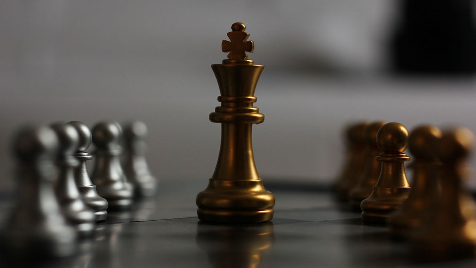 Gold chess king surrounded by silver and gold pawns on a board. Dark, blurred background creates a dramatic mood.