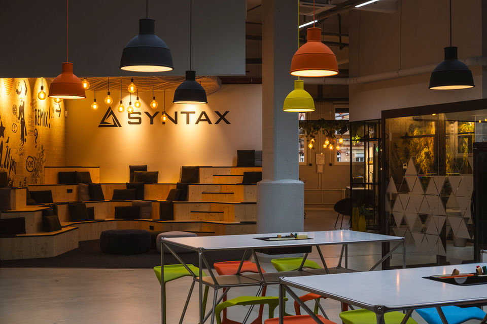 Modernes Büro in einer umgebauten Lagerhalle mit industriellem Design, offenen Arbeitsbereichen und moderner Beleuchtung