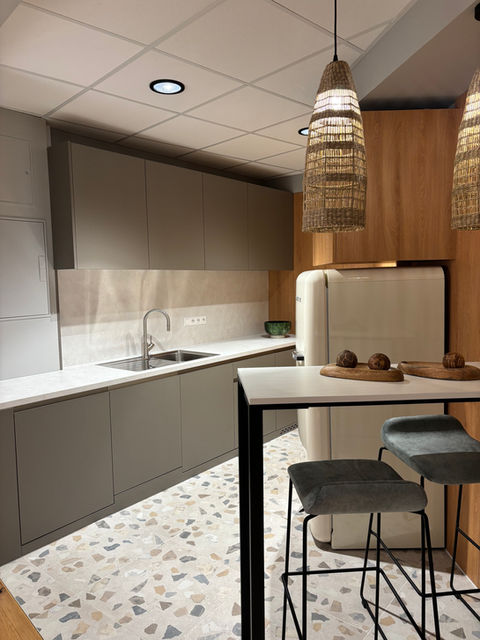 Moderne Büroküche mit Küchenzeile, Hochtisch, Barhockern und warmer Beleuchtung im Office