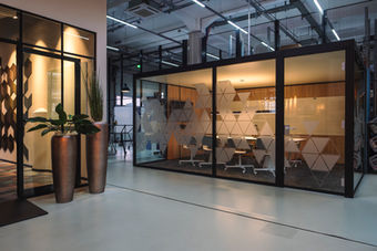 Verglaste Meetingräume in einem modernen Büro mit industriellem Design und offenem Raumkonzept