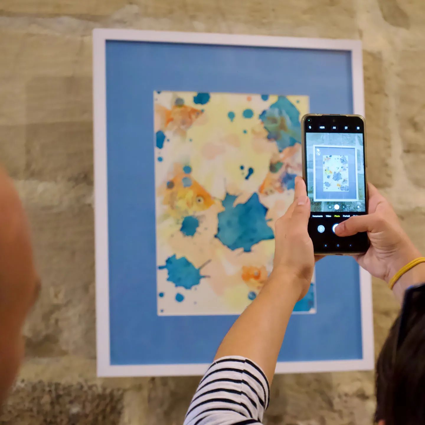 Taking a photograph of their favourite artwork depicting an abstract realist original goldfish painting