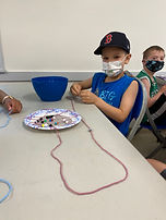 Camper with face mask doing crafts