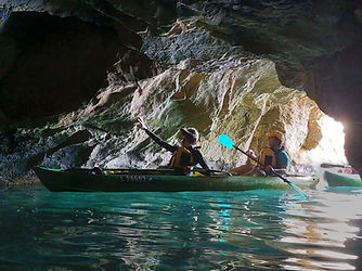 Paddlers kayaking inside a sea cave near Fort St Angelo in Birgu during a guided Grand Harbour sea kayaking adventure in Malta