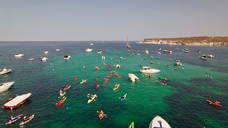 Drone view of a large kayaking gathering in San Tumas Bay, Malta, supporting marine ecotourism and environmental awareness.