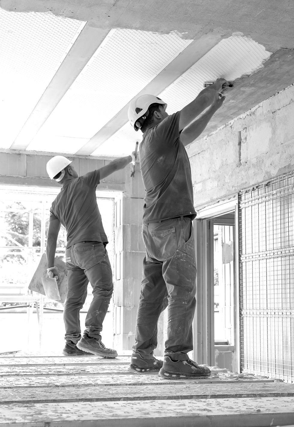 craftsmen-grey-clothes-working-inside-room-standing-scaffoldings-construction