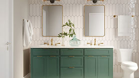 A picket style tile wall with a vibrant green vanity, brass finishes, two mirrors and brass light fixtures.