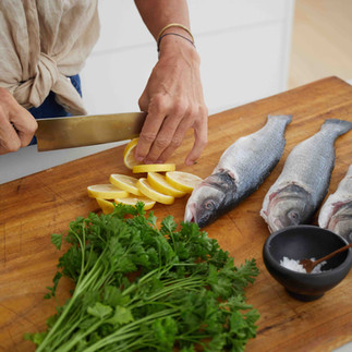 Woman at a cutting board slicing lemons