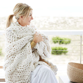 Elegant woman wrapped in a knitted shawl. 