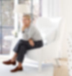 Beautiful woman perched on a white wing chair