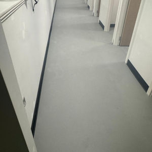 Narrow hallway with gray flooring and white walls.