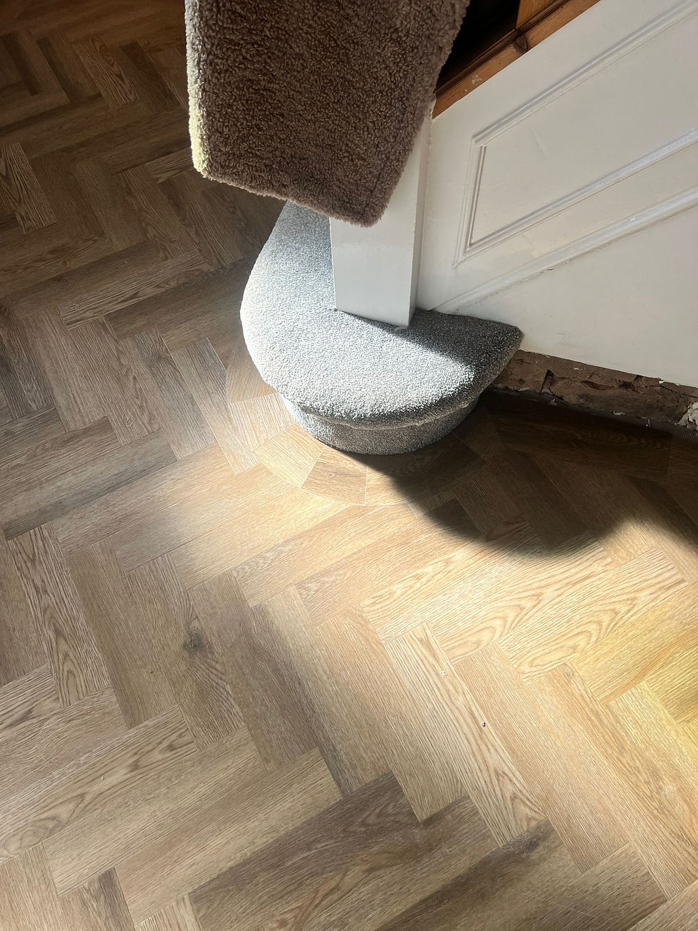 Parquet LVT flooring close-up of a one tile border going around a round bottom step in a hallway
