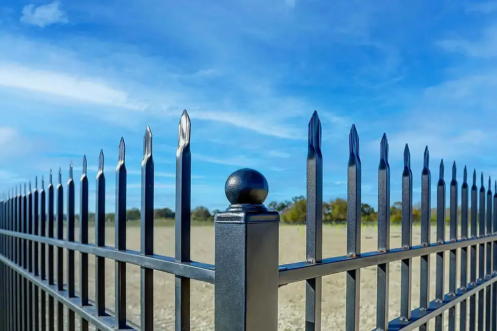 Security fencing with sharp points surrounding a parking lot.