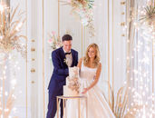front-view-bride-groom-standing-bright-stage-with-decoration-cutting-wedding-cake-together
