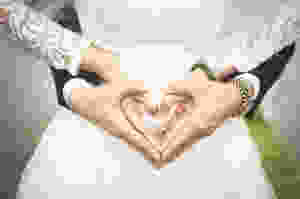 midsection of woman making heart shape with hands