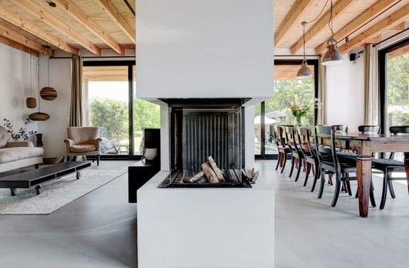 interieurfotografie met zichtlijn naar de woonkamer en eetkamer , mooi natuurlijk daglicht en kalme minimalistische sfeer , gefotografeerd met gevoel voor esthetiek en strak gekaderd.