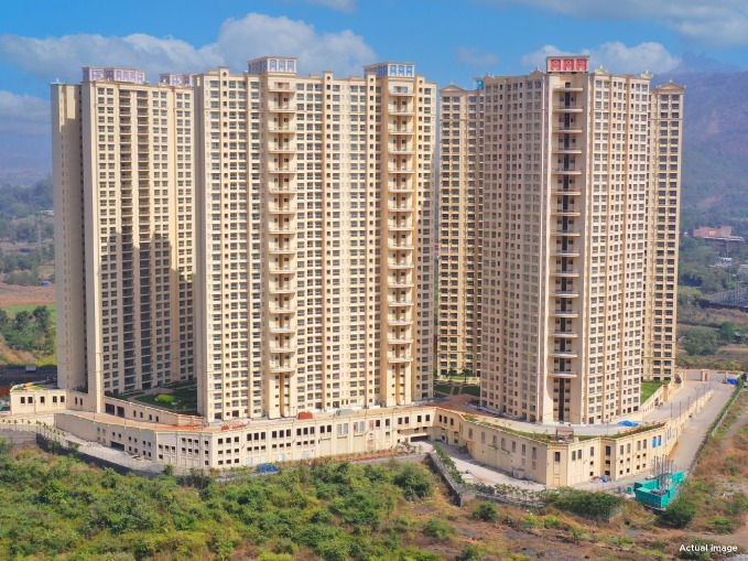 Eye-level view of a broad road leading towards residential towers near Panvel