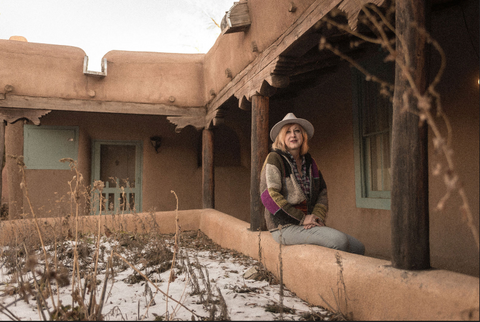 Singer Suzy Webb Boles sitting on a wall in New Mexico
