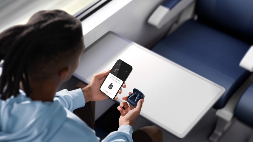 Homem segurando os fones Liberty 4 NC e um celular