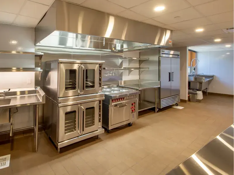 refrigerador para cocina de restaurante en una cocina equipada con hornos industriales y campana extractora de acero.