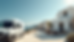 Eye-level view of a sleek white van parked outside a traditional Mykonos villa with luggage being loaded