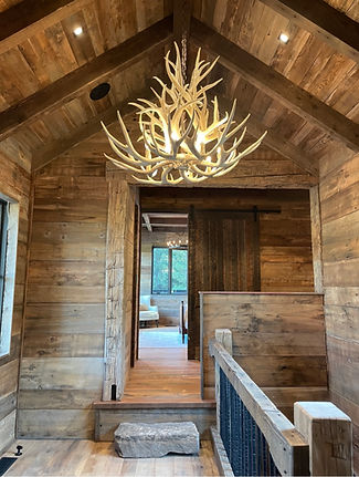 Large mule deer antler chandelier hanging in rustic foyer, custom handcrafted rustic light