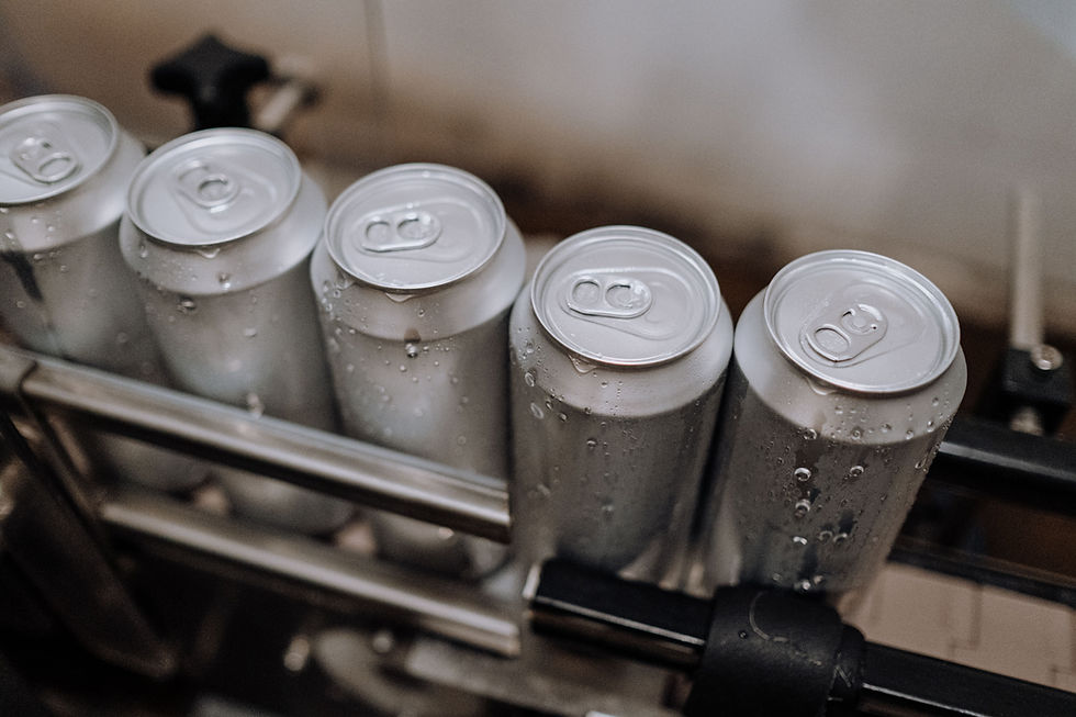 Close-up of chilled, unlabelled aluminium beverage cans on the production line.