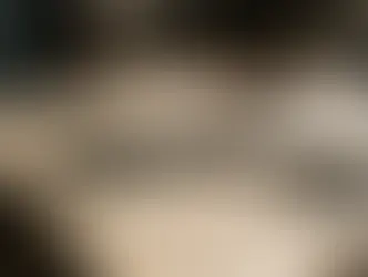 Uma tesoura antiga de alfaiate repousando sobre páginas de um manuscrito amarelado, simbolizando a edição e a poda.