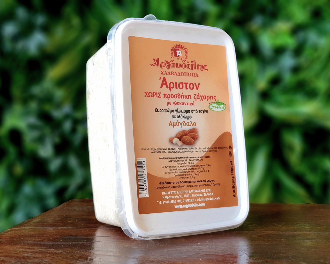 Αμύγδαλο γλύκισμα ταχινιού χωρίς ζάχαρη επάνω σε τραπέζι και μπροστά από πρασινάδα.