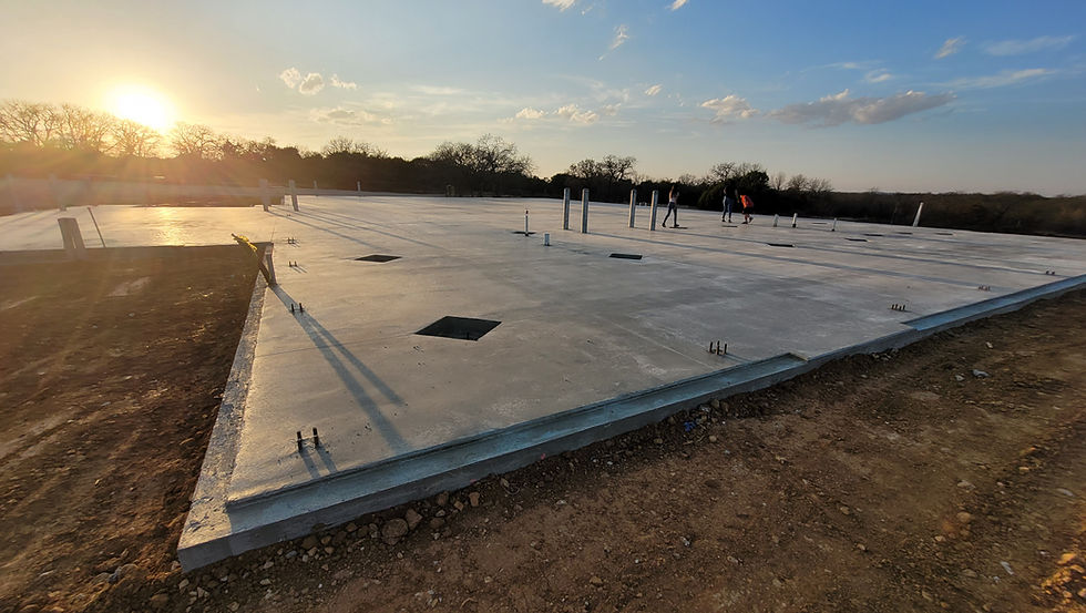 Concrete slab foundation at sunset for new home construction.