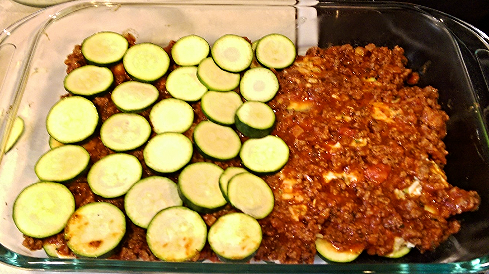 2nd layer of zucchini coins going over the sauce mixture.