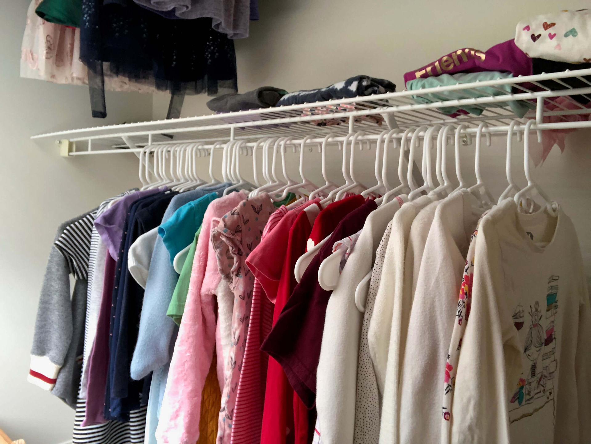 kids clothes hanging in closet