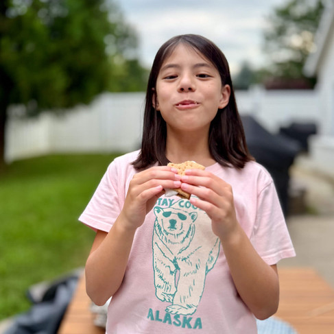 girl happily eating s'more