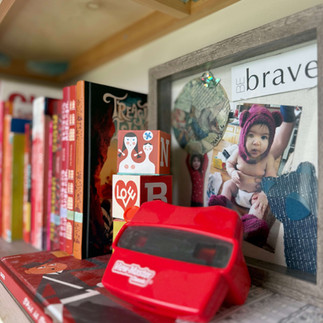 classic red viewfinder toy next to books with red spines