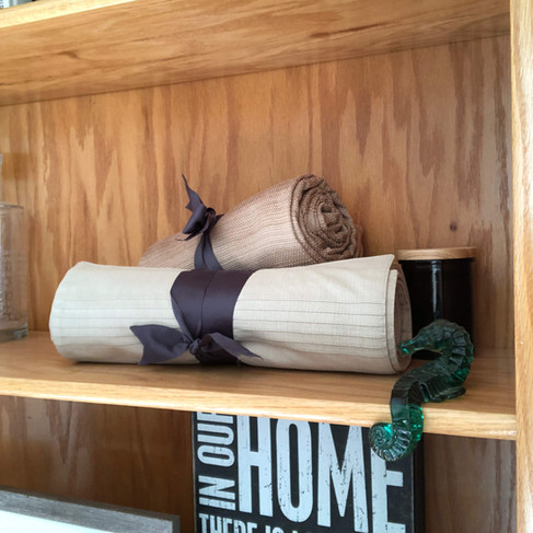Tablecloth and placemats rolled up make functional shelf decor