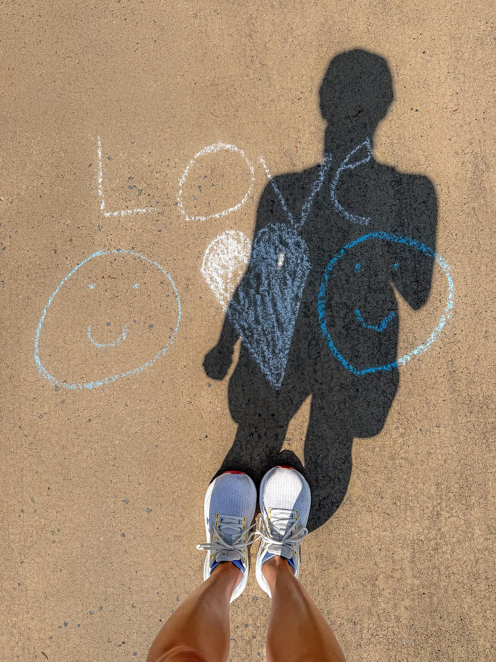 Jennifer's standing shadow over "love" written in chalk on driveway
