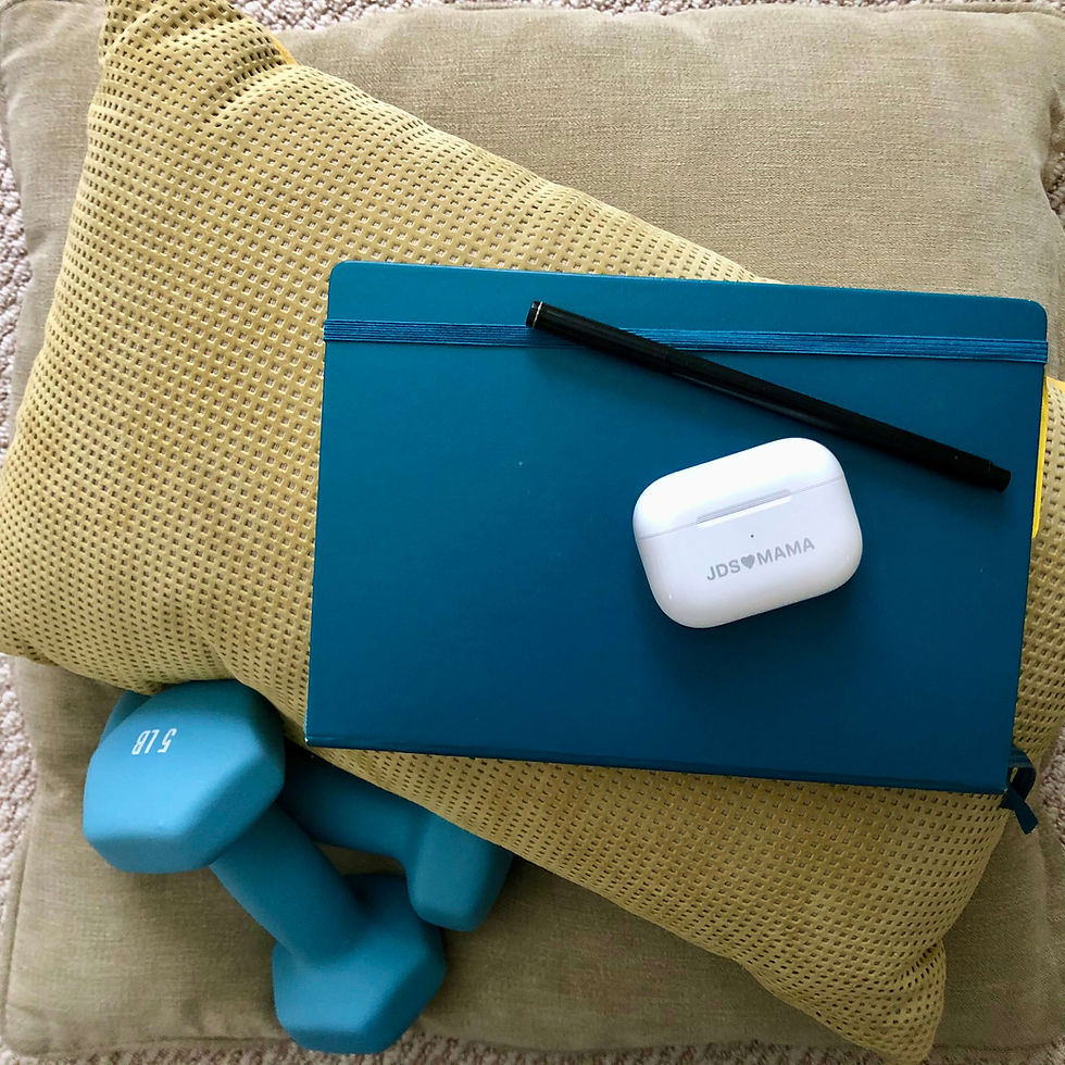 airbuds on teal journal next to 5lb blue weights laid out ready for morning ritual