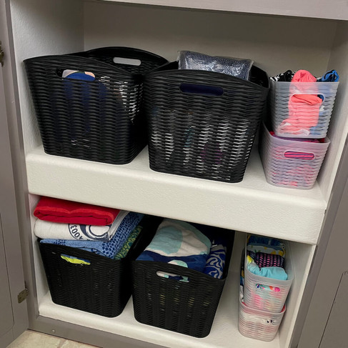 Swimsuits and beach towels neatly contained in bins