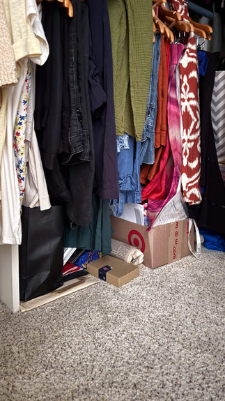 boxes of sentimental items hidden under clothes in closet