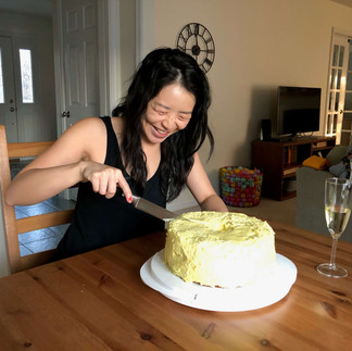 Jennifer smiling as she cuts into her birthday lemon chiffon cake
